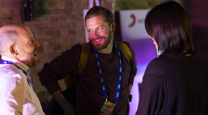 Three men engaged in conversation 