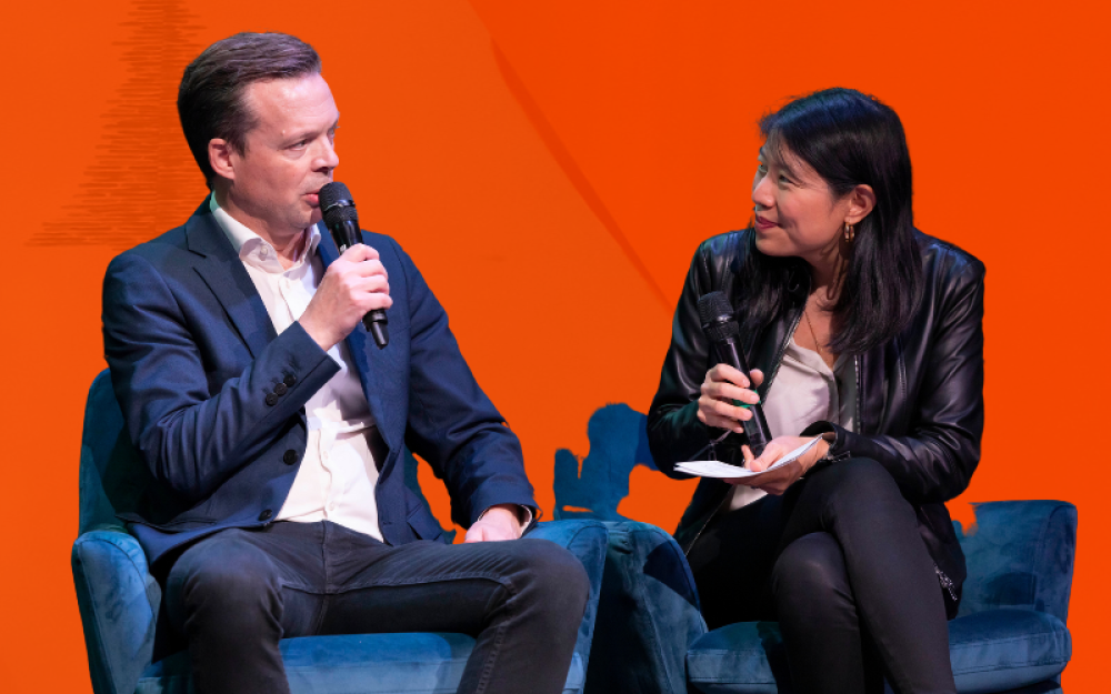 two speakers on an orange background